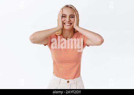 Jolie femme caucasienne insouciante dans un t-shirt à rayures avec tatouages, joues de crissement et joyeux sourire, elle a l'air heureuse et gaie, s'amuser, être Banque D'Images