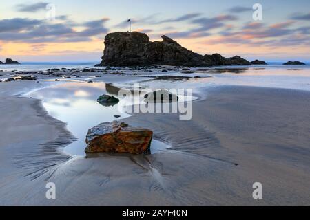 Chapelle Rocher sur Broad Oak Beach à Cornwall capturé au coucher du soleil. Banque D'Images