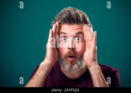 Un portrait de barbu surpris homme en t-shirt rouge. Concept de personnes et d'émotions Banque D'Images