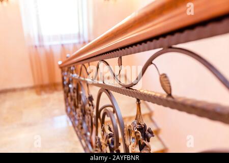 escalier en fer forgé dans le cottage. Marches en marbre, escaliers en fer forgé noir avec ornements floraux. Rambarde en bois d'acajou. L'escalier entre f Banque D'Images