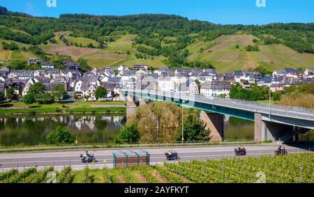 Pont traversant la Moselle qui mène au village Wolf et aux vignobles environnants sur les collines sous un ciel bleu. Wolf, Traben-Trarbach, Allemagne. Banque D'Images