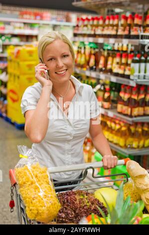 Eine junge Frau kauft Obst und Gituese auf einem Wochenmarkt. Ernaehrung und Ausführung von Grünen. Banque D'Images