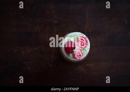 Belle tasse de gâteaux fleurs de crème de beurre, en rouge et rose. Idéal pour l'anniversaire, l'anniversaire, la Saint-Valentin et les fêtes. Foyer sélectif Banque D'Images