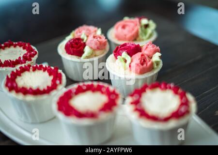 Belle tasse de gâteaux fleurs de crème de beurre, en rouge et rose. Idéal pour l'anniversaire, l'anniversaire, la Saint-Valentin et les fêtes. Foyer sélectif Banque D'Images