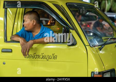 Thaïlande, Phuket, Patong, 1er février 2020: Blurr, soft focus, tuk tuk chauffeur, Thai homme assis dans son taxi jaune et attendant les clients, taxi, cl Banque D'Images