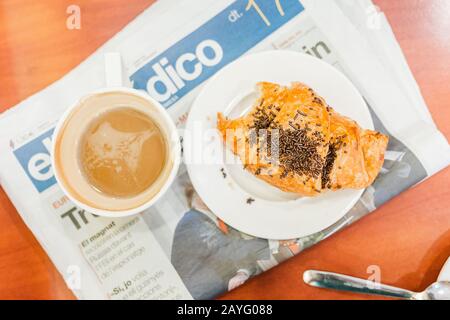 17 JUILLET 2018, REUS, ESPAGNE : café noir du matin avec croissant et journal politique Banque D'Images