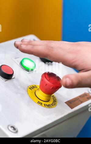 Appuyez à la main sur le bouton d'urgence rouge ou le bouton d'arrêt pour la machine industrielle, Arrêt d'urgence pour la sécurité . Banque D'Images