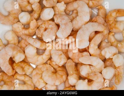 Vue de dessus vue rapprochée des crevettes fraîches crues piquées congelées, fond blanc Banque D'Images