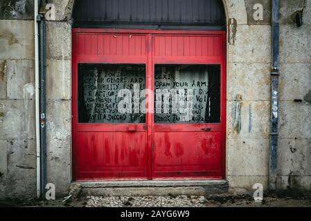 Porte en bois rouge vif colorée dans une porte voûtée Banque D'Images