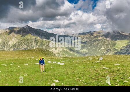 Une femme heureuse voyage dans les Pyrénées en Andorre et en Espagne. Marche nordique, loisirs et trekking le long de la piste de chemin de 11 Banque D'Images