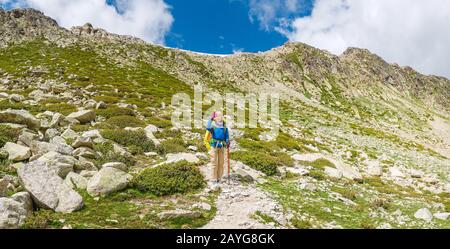 Une femme heureuse voyage dans les Pyrénées en Andorre et en Espagne. Marche nordique, loisirs et trekking le long de la piste de chemin de 11 Banque D'Images