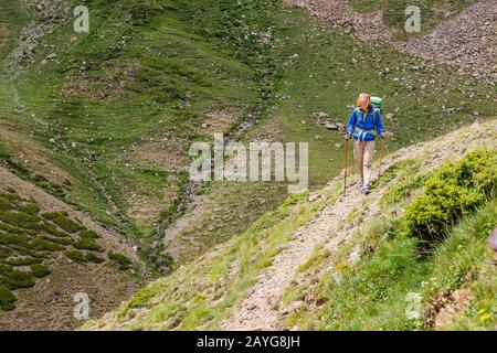 Une femme heureuse voyage dans les Pyrénées en Andorre et en Espagne. Marche nordique, loisirs et trekking le long de la piste de chemin de 11 Banque D'Images