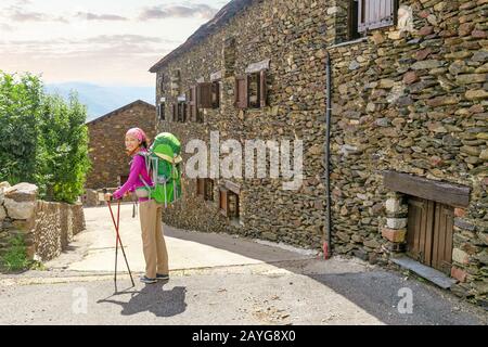 Pilgrim Woman ranker sur un chemin à travers la vieille ville ou le village Banque D'Images