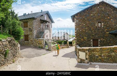 Pilgrim Woman ranker sur un chemin à travers la vieille ville ou le village Banque D'Images