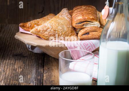 assortiment de pâtisseries et de lait pour le petit-déjeuner sur une ancienne table en bois Banque D'Images