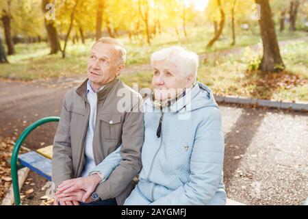 Couple senior âgé amoureux se reposant sur un banc dans le parc d'automne Banque D'Images