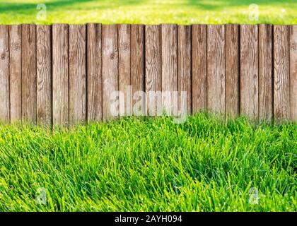 Clôture de jardin en bois au jardin avec l'herbe verte Banque D'Images