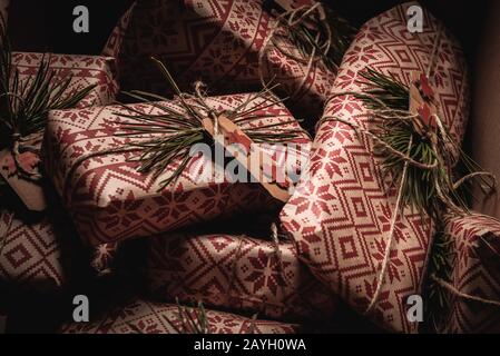 De nombreux cadeaux de noël se sont enroulés dans une boîte avec un cadeau original et décoratif rustique de bricolage enveloppé dans du papier d'emballage rétro vintage naturel Banque D'Images