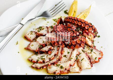 Carpaccio de poulpe délicieux avec dressing sur plaque blanche. Mets de fruits de mer Banque D'Images