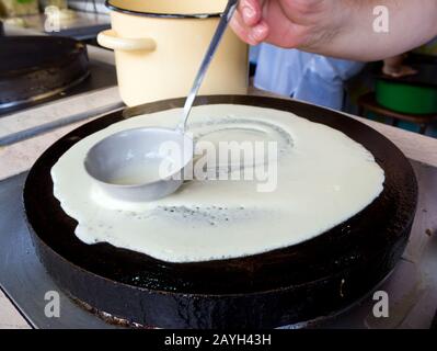 Le processus de fabrication de crêpes sur un poêle à crêpes électrique Banque D'Images