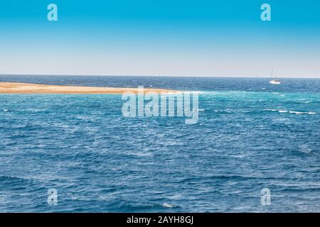 Belle plage de sable et un bateau à voile à la distance Banque D'Images