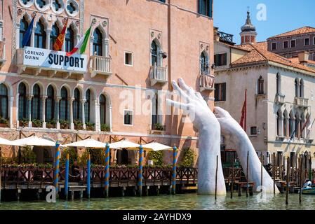 Venise, Italie - 18 mai 2017 : des mains géantes montent de l'eau du Grand Canal pour soutenir le bâtiment. Ce puissant rapport sur le changement climatique de Banque D'Images