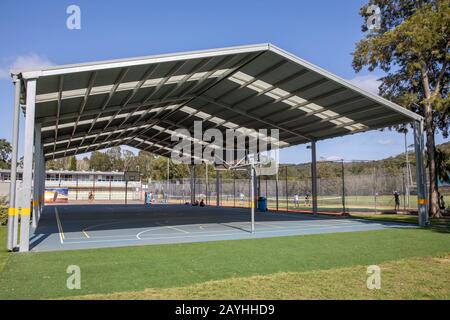 Terrain de basket-ball scolaire australien à l'ombre et courts de tennis scolaires adjacents, Sydney, Australie Banque D'Images