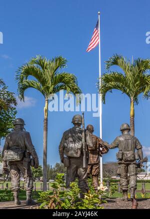 Oahu, Hawaï, États-Unis. - 10 janvier 2012: Unis Dans la statue du groupe sacrifice vu de l'arrière devant le drapeau américain sous le bleu de skay à Schofield Barracks d'Ar Banque D'Images