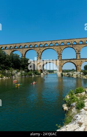 Les gens qui font du kayak sur la rivière Gardon au Pont du Gard (site classé au patrimoine mondial de l'UNESCO), un ancien aqueduc romain, près de Nîmes dans le sud de la France. Banque D'Images