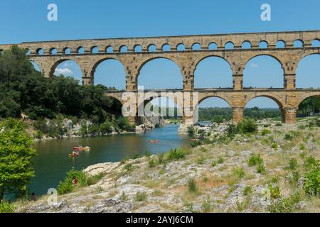 Les gens qui font du kayak sur la rivière Gardon au Pont du Gard (site classé au patrimoine mondial de l'UNESCO), un ancien aqueduc romain, près de Nîmes dans le sud de la France. Banque D'Images