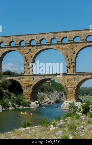Les gens qui font du kayak sur la rivière Gardon au Pont du Gard (site classé au patrimoine mondial de l'UNESCO), un ancien aqueduc romain, près de Nîmes dans le sud de la France. Banque D'Images