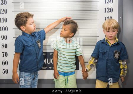 Les garçons de l'école primaire jouent à la police et aux prisonniers. Banque D'Images