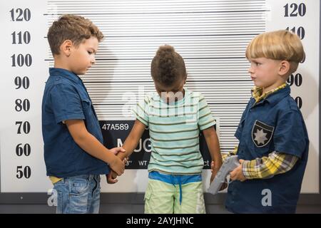 Petits garçons jouant la police et prisonnier. Banque D'Images