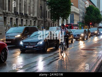 London Traffic,Jam,Euston Road,Pluie,Cycliste,On Mobile,Pas De Feux,Dusk,Londres,Angleterre Banque D'Images