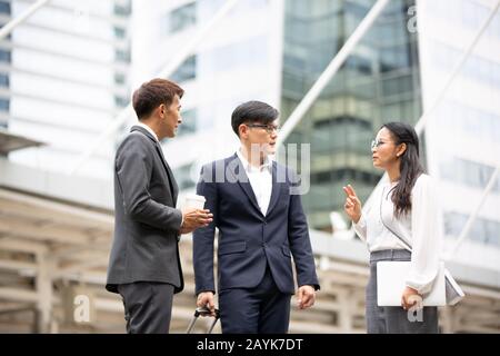 Groupe de gens d'affaires se tenant à la main sur l'accord d'affaires ou le travail d'équipe contre le bâtiment Banque D'Images