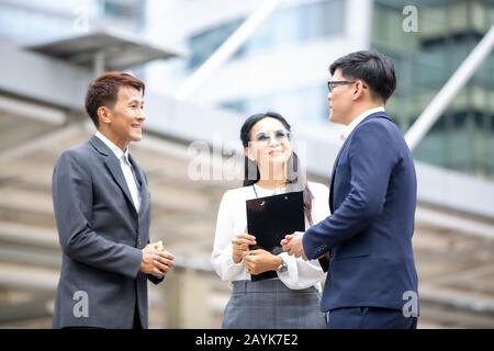 Groupe de gens d'affaires se tenant à la main sur l'accord d'affaires ou le travail d'équipe contre le bâtiment Banque D'Images