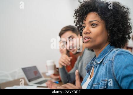 Groupe de personnes d'affaires créatives à l'écoute d'un collègue lors d'une réunion de bureau. Concept d'entreprise et de brainstorming. Banque D'Images