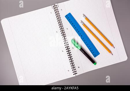 Les crayons, le stylo et la règle se trouvent sur un ordinateur portable ouvert. Bureau. Fournitures scolaires. Banque D'Images