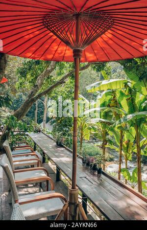 Magnifique café extérieur avec parasols traditionnels rouges thaïlandais en Thaïlande. Banque D'Images