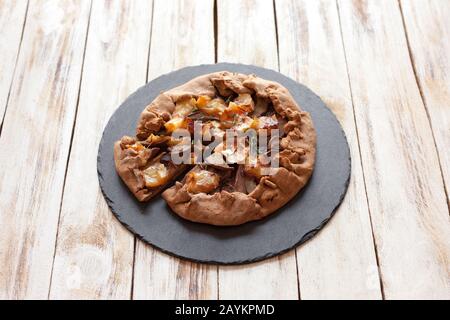 Galette aux poires et au fromage Brie. Appelée aussi galette bretonne, galette des Rois, Galeta. Cuisine française. Sur fond blanc en bois ancien. Banque D'Images