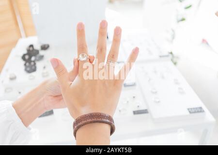 Une femme essayant sur l'anneau de bijoux à la boutique. Boutique de luxe et concept commercial Banque D'Images