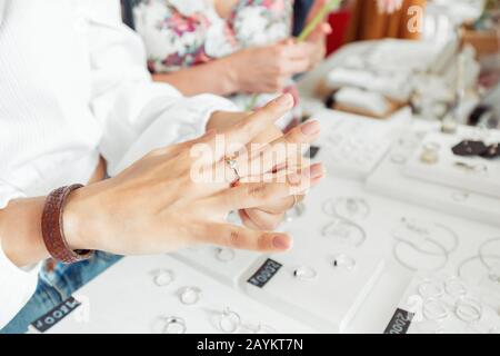 Une femme essayant sur l'anneau de bijoux à la boutique. Boutique de luxe et concept commercial Banque D'Images