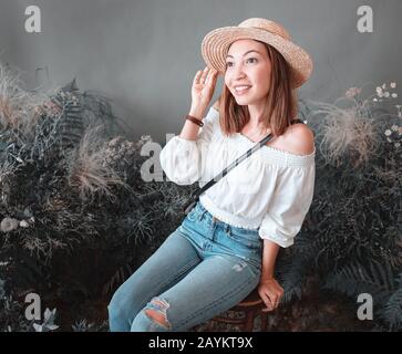 femme d'entrepreneur de fleuriste posant parmi des fleurs rustiques en studio Banque D'Images