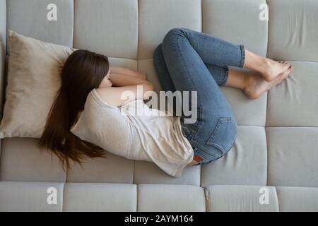 Vue de dessus de la jeune femme couchée sur le canapé Banque D'Images