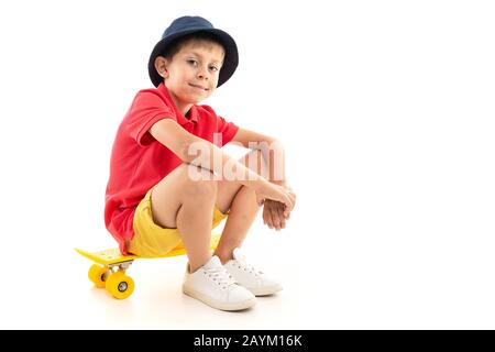 Beau adolescent caucasien dans un t-shirt sombre, veste assise avec un sou jaune, isolée sur fond blanc Banque D'Images