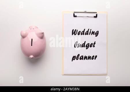 Une banque de piggy à économie pleine de pièce de monnaie et un mini-presse-papiers Banque D'Images