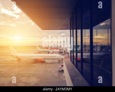 avion à la porte du terminal de l'aéroport, aéroport international moderne pendant le coucher du soleil. transport par avion et concept de voyage Banque D'Images