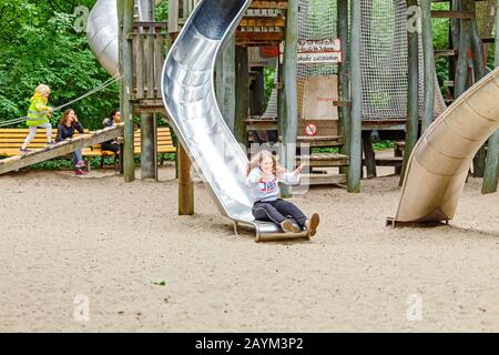 18 MAI 2018, BERLIN, ALLEMAGNE: Les enfants heureux qui profitent de toboggans sur le nouveau terrain de jeu dans le parc Banque D'Images