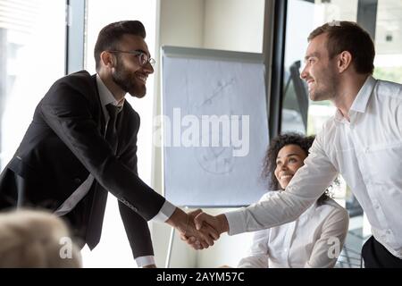 Les partenaires commerciaux multiethniques se serrent les mains pour entamer des négociations Banque D'Images