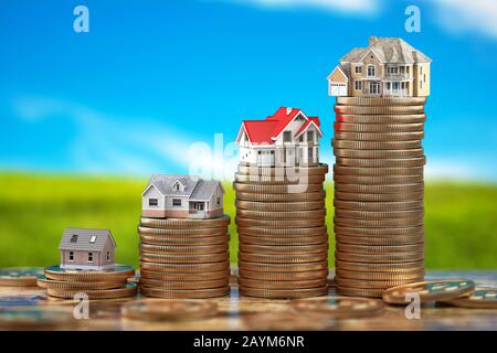 Maisons de taille différente avec sur piles de pièces. Concept d'investissement immobilier, immobilier et immobilier. illustration tridimensionnelle Banque D'Images